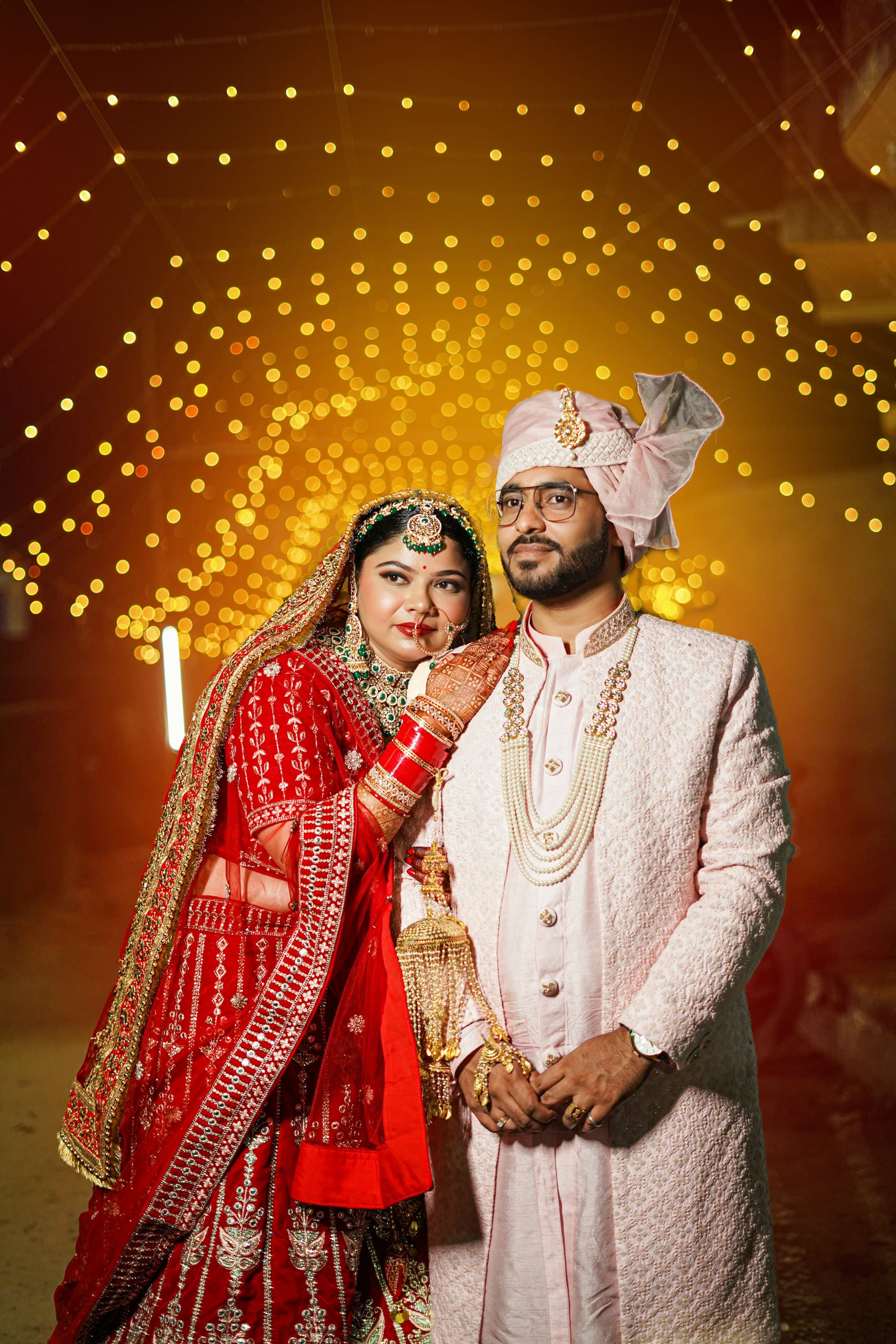 A bride and groom sharing a warm moment under string lights at night