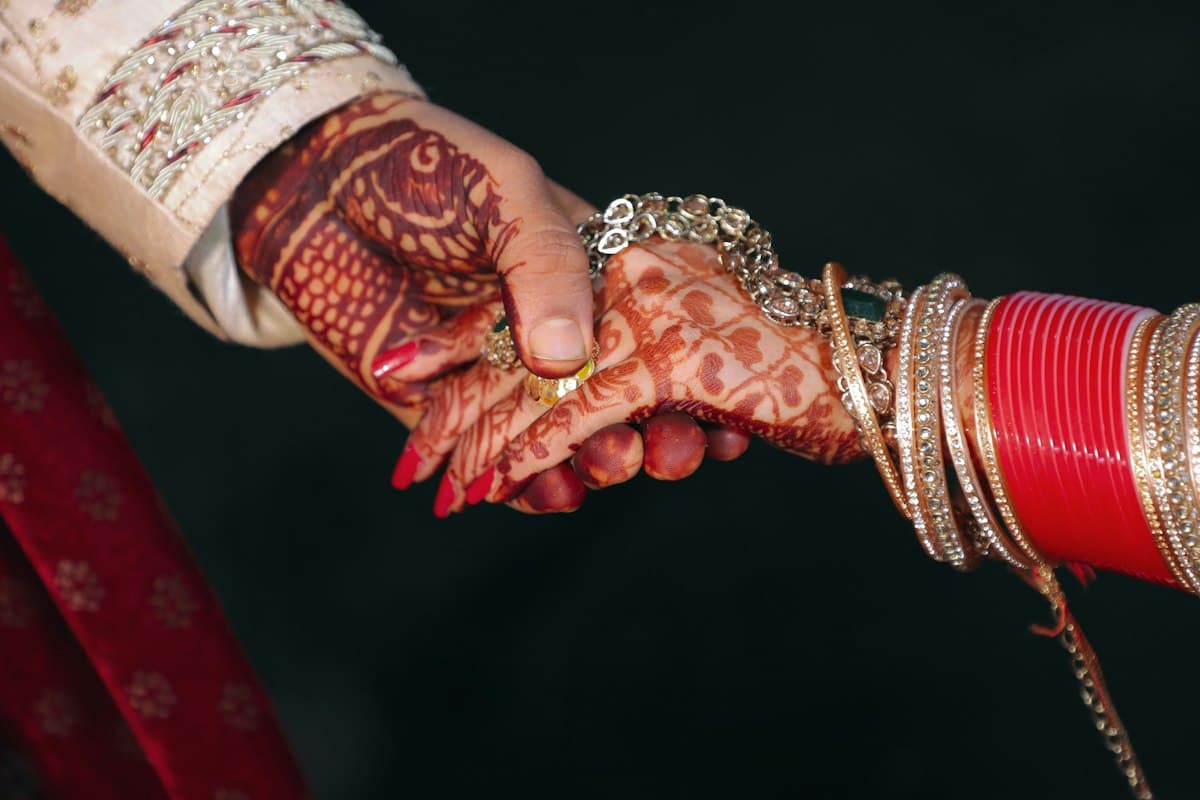 Close-up of hands with traditional henna and bangles at an Indian wedding