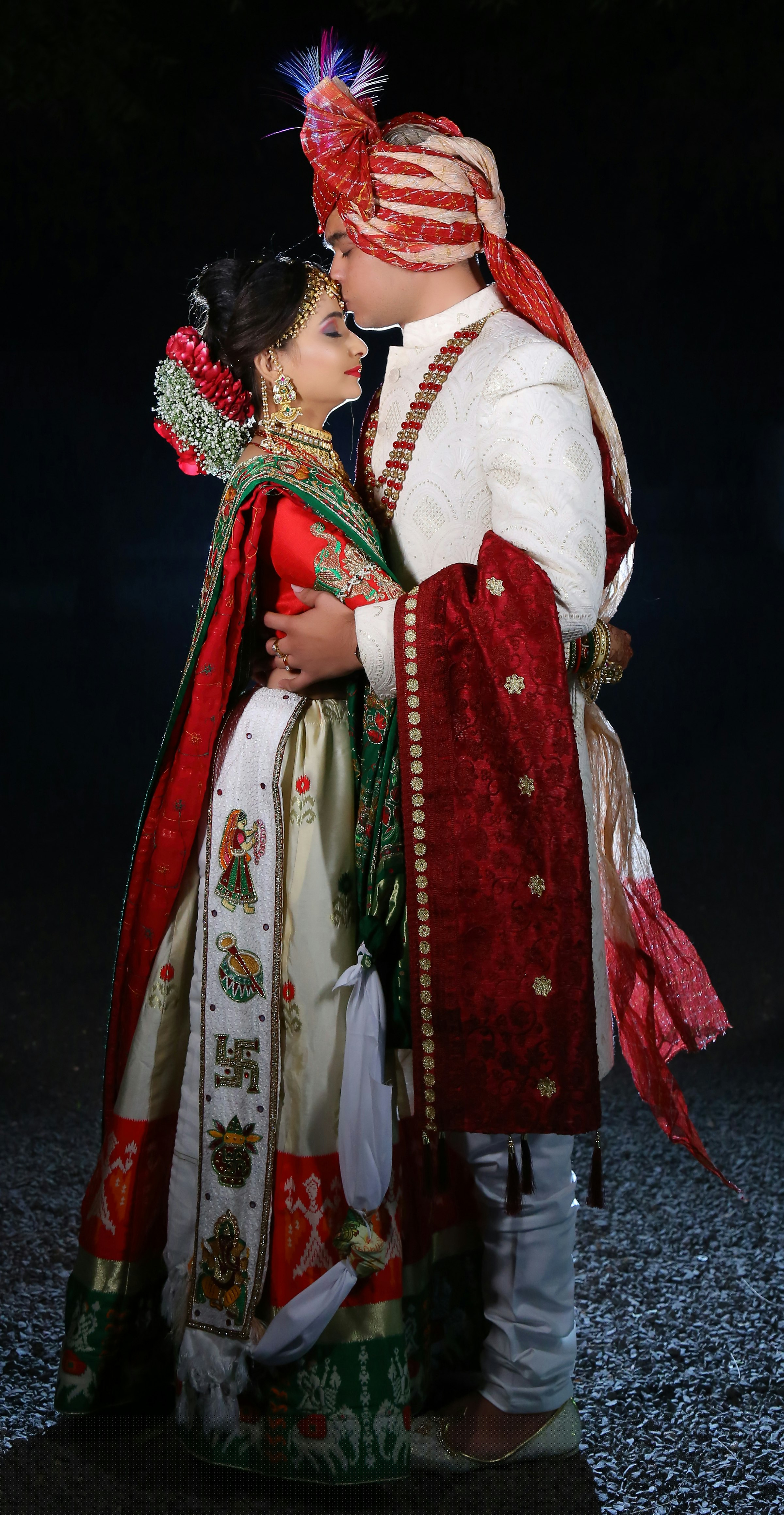 A close, intimate moment between a bride and groom in traditional Indian wedding attire